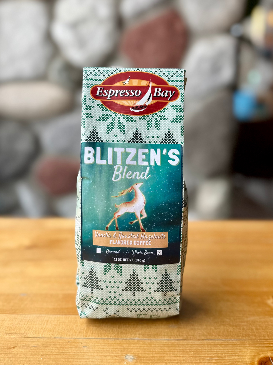 Box of Espresso Bay Blitzen's Blend coffee on a wooden surface with a stone wall background