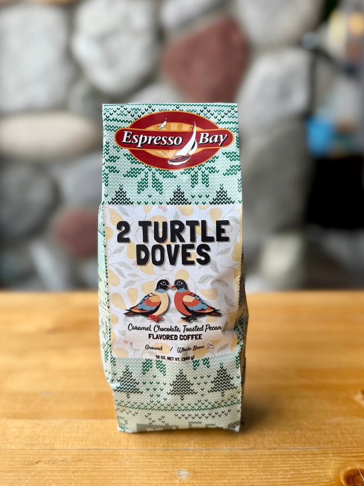 Espresso Bay 2 Turtle Doves coffee package on a wooden surface with a blurred background