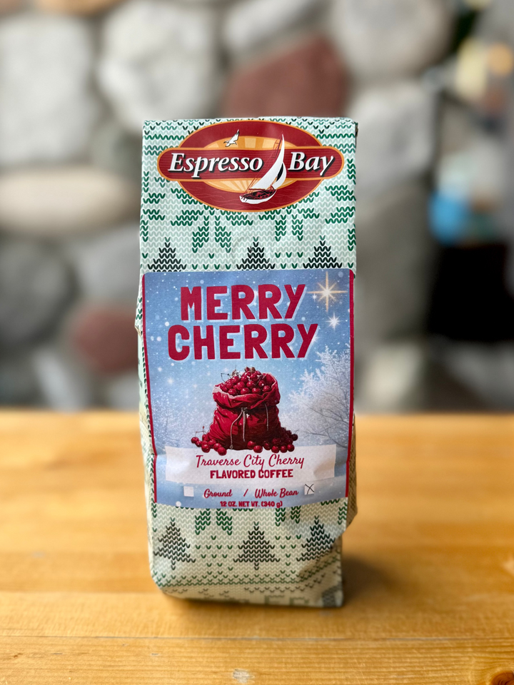 Espresso Bay Merry Cherry coffee package on a wooden surface with a blurred background
