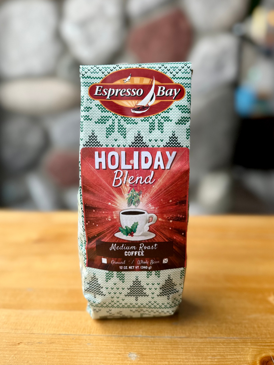 Espresso Bay Holiday Blend coffee package on a wooden surface with a blurred background